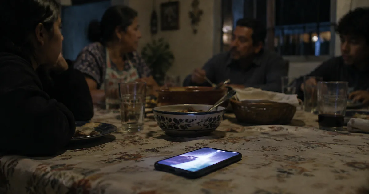 Imagen generada con IA: teléfono boca abajo sobre un escritorio junto a una taza